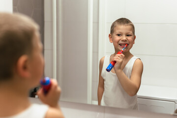 little boy brushing his teeth in bathroom