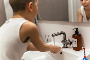 little washing hands in bathroom