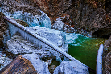 beautiful landscape with a mountain river with small waterfalls in winter day in the canyon.