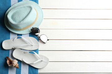Beach accessories on white wooden table, flat lay. Space for text