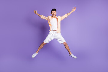 Full size photo of hooray brunet guy jump wear peach shirt shorts sneakers isolated on lilac background