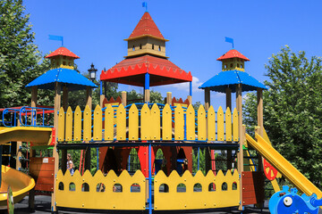 Beautiful wooden children s entertainment game complex - slides, stairs, swings, houses in street....