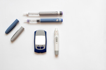 Insulin short, long, glucose meter, test strips and finger piercing pen on a white isolated background. Set for diabetics with mock up