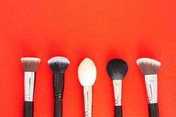 Set of large cosmetic brushes on red background