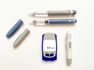 Insulin short, long, glucose meter, test strips and finger piercing pen on a white isolated...