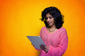 Beautiful young indian woman looking for informations on her touchscreen tablet - Pretty Sri Lanka girl uses pad wiewing elearning lessons browsing blogs touching the display with her hand