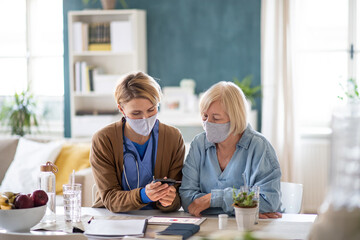Caregiver or healthcare worker with senior woman patient, measuring blood glucose indoors. - obrazy, fototapety, plakaty