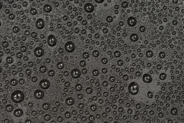 Water drops on black background texture. Dark backdrop glass covered with drops of water. gray bubbles in water