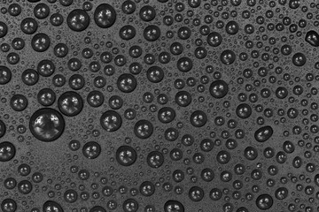 Water drops on black background texture. Dark backdrop glass covered with drops of water. gray bubbles in water