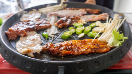 Selective focused Samgyeopsal or Korean BBQ , pork belly on grilling pan.