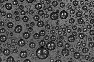 Water drops on black background texture. Dark backdrop glass covered with drops of water. gray bubbles in water