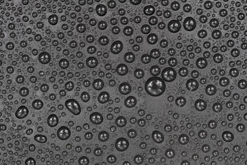 Water drops on black background texture. Dark backdrop glass covered with drops of water. gray bubbles in water