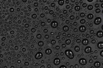 Water drops on black background texture. Dark backdrop glass covered with drops of water. gray bubbles in water