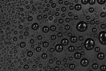 Water drops on black background texture. Dark backdrop glass covered with drops of water. gray bubbles in water