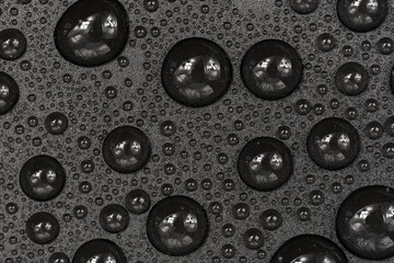 Water drops on black background texture. Dark backdrop glass covered with drops of water. gray bubbles in water