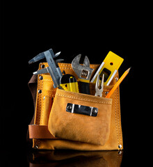 Tool kit in suede bag for plumber or construction craftsman on black isolated background