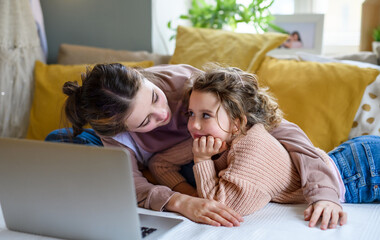 Sisters indoors at home, using laptop. Lockdown concept.