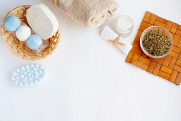 Home spa salon, cosmetics, soap, sponge, towel, bath salt, dry herbs, top view, copy space