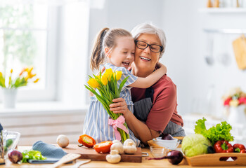 Granddaughter is giving flowers to her grandmother