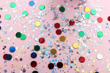 Shiny glitter on light pink background, above view
