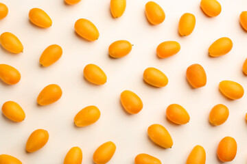 Fresh ripe kumquats on light background, flat lay