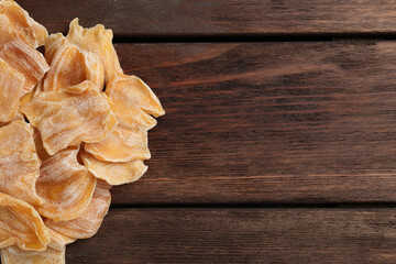 Delicious dried jackfruit slices on wooden table, flat lay. Space for text