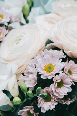 Beautiful flowers in wrapping: white big roses and wildflowers. Spring background.