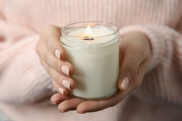 Woman holding burning candle with wooden wick, closeup - Powered by Adobe