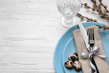 Festive Easter table setting with eggs on white wooden background, flat lay. Space for text