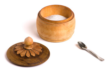Wooden bowl with salt, cover with petals and little spoon on white background.