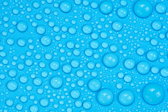 Water drops on blue background texture. Backdrop glass covered with drops of water. bubbles in water