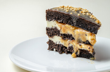 chocolate biscuit cake with nuts. with condensed milk on a white platter High quality photo