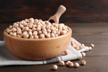 Chickpeas in bowl on wooden table, space for text