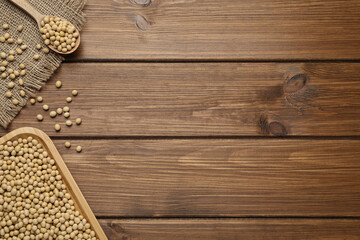 Soya beans with dishware on wooden table, flat lay. Space for text