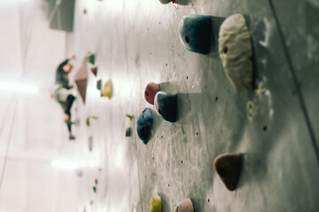Rocks on climbing wall. Fitness, extreme sport, bouldering, people and healthy lifestyle concept -...