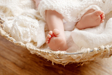 Fototapeta na wymiar Newborn baby feet on creamy blanket. Maternity, family, birth concept.