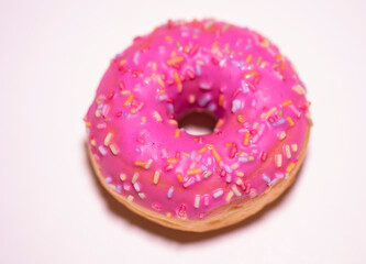 Homemade circle donut with pink icing and rainbow sprinkles