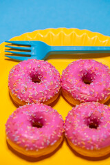 Homemade circle donut with pink icing and rainbow sprinkles