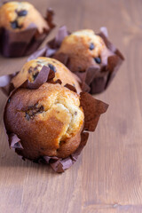 Close-up of chocolate muffins, with selective focus, on wooden table, in vertical