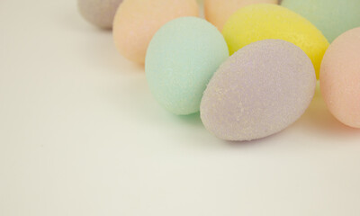Multicolored decorative eggs on a white background. Festive background. Happy Easter. Place for text.