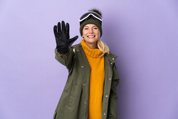Skier Russian girl with snowboarding glasses isolated on purple background counting five with fingers