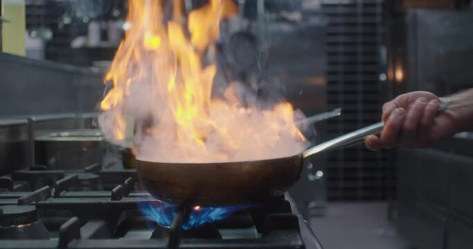 The cook is working with the pan