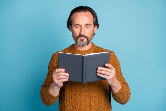 Photo portrait of serious professor reading book spending free time isolated on vibrant blue color background