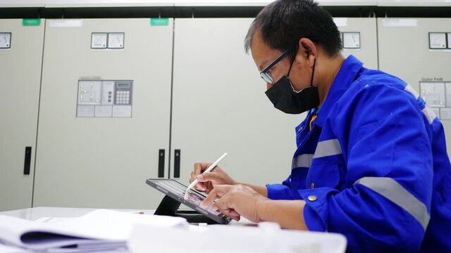 Senior engineer to engineering design with tablet computer in Electrical control room