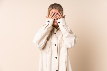 Blonde woman over isolated background covering eyes by hands