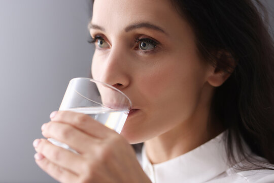 Young Brunette Woman Drinking Water From Glass