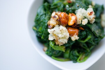 Spinat Salat mit Knoblauch, Chili, Erdnüssen, Sojasoße, Sesamöl, heller Essig, Salz und Pfeffer