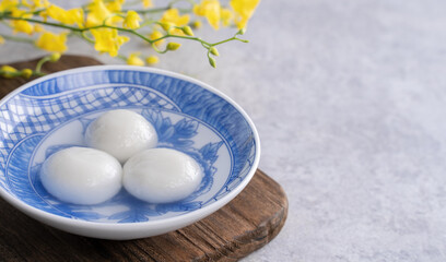 Close up of yuanxiao tangyuan in a bowl on gray table, food for Chinese Lantern Yuanxiao Festival.