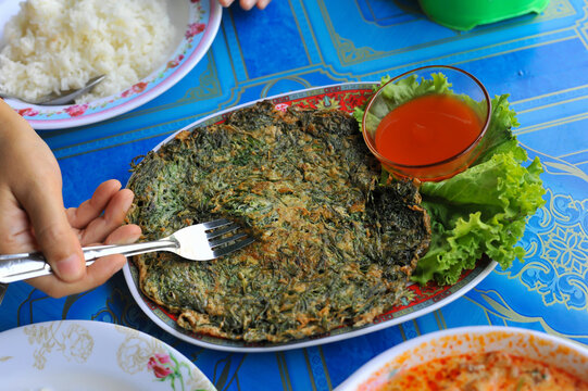 Top view of Authentic Thai style omelet with Suaeda Maritima leaves eat (The Local food ) with ketchup at Wat Khun Samut Chin temple, Samut Prakan province , Thailand