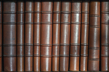 old collection of books untitled on a shelf with brown leather cover, knowledge background